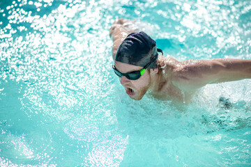 Fototapeta na wymiar Man in swimming goggles having a workout in pool