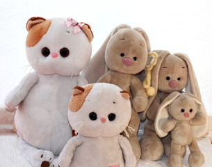 Soft toys kittens and bunnies on a light background.