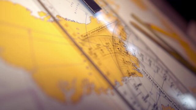 Plotting position on navigational chart at sea. Marine Map and ruler. Sowmotion shot