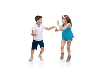 Obraz na płótnie Canvas Happy kids, little and emotional caucasian boy and girl jumping and running isolated on white background. Look happy, cheerful, sincere. Copyspace for ad. Childhood, education, happiness concept.