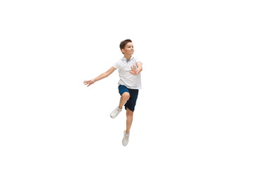 Happy kids, little and emotional caucasian boy jumping and running isolated on white background. Look happy, cheerful, sincere. Copyspace for ad. Childhood, education, happiness concept.