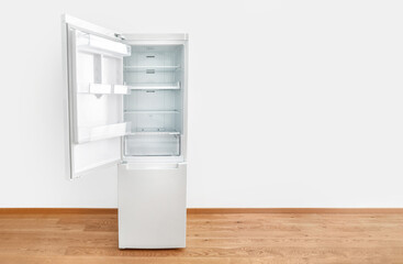 Open white fridge on white wall background