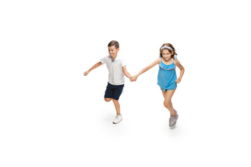 Fototapeta na wymiar Happy kids, little and emotional caucasian boy and girl jumping and running isolated on white background. Look happy, cheerful, sincere. Copyspace for ad. Childhood, education, happiness concept.