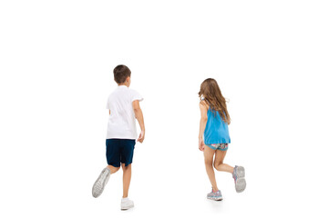 Obraz na płótnie Canvas Happy kids, little and emotional caucasian boy and girl jumping and running isolated on white background. Look happy, cheerful, sincere. Copyspace for ad. Childhood, education, happiness concept.