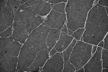 background close up of black cracked tar skin black with sand in cracked texture
