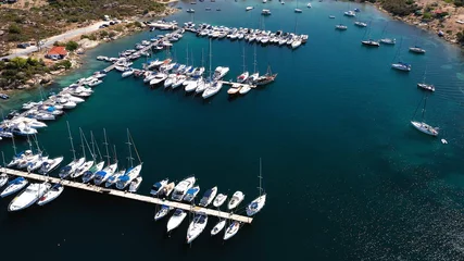 Aerial view of a blue ocean near a harbor shore at daytime © Martin Stoychev/Wirestock