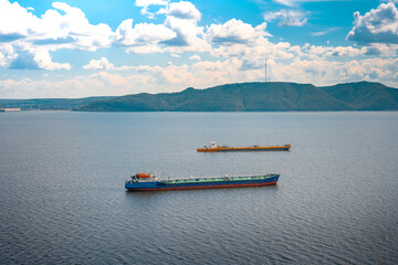 Merchant ships sail on the river on a summer day