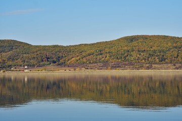 forest reflected in the lake in autumn season