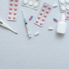 top view of thermometer, pills and nasal spray on white background