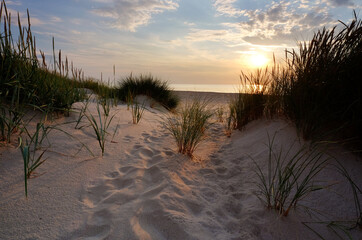Zachód słońca ,plaża w Kołobrzegu,biały piasek,wydmy na wybrzeżu Morza Bałtyckiego.