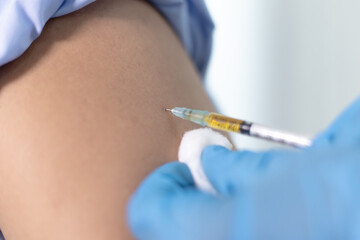 Doctor is vaccinating against Asian men in the hospital.