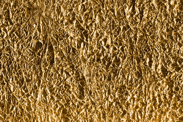 Gold foil texture with folds and cracks. Gradient golden background with high resolution.	

