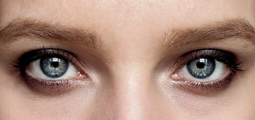 Evening makeup Smokey eyes. Beautiful blue eyes of a girl close-up. Design of a beauty banner.
