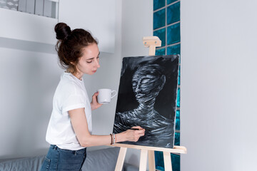 beautiful woman paints portrait, silhouette mummy with closed eyes, looks enjoys picture, gets...