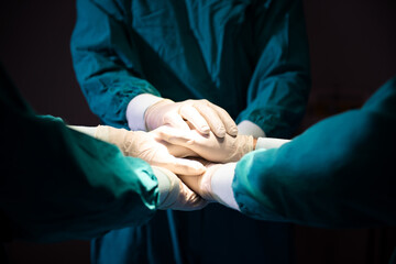 Group Surgeon doctor joining hands before Patient surgery in hospital operating theater .   Teamwork medical doctor working  performing surgery.