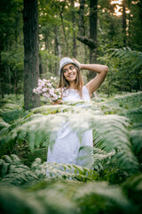Girl in a white dress among the ferns. Malt Girl with Long Hair in the Fern Park. Girl and fern