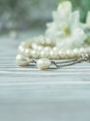 White pearl necklace with white flowers, macro.