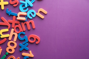 colorful plastic letters on purple background, Top view 