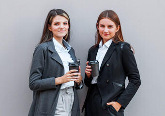 Two business women enjoying a cup of coffee and smiling
