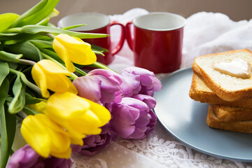 Homemade breakfast in bed. Toast with peanut butter, a cup of coffee and tulips. Good morning.