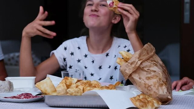 Young Girl Enjoying A Fried Dumpling With Taste. An Irresistible Homemade Italian Specialty Typical Of The Emilia Romagna Region, A Soft Dough Cut Into Lozenges And Fried, Swollen And Golden. 