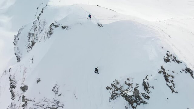 Aerial drone shot of snowboarders free riding slope at La Plagne ski resort, Tarentaise, Savoy, French Alps
