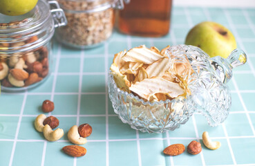 Dried apples, apple chips. Healthy snack, diet. Dried apples on a background of oatmeal, apple juice and nuts. Cashews, almonds, hazelnuts