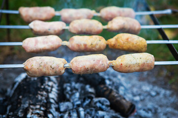 Delicious sausages on a skewer. Rest, friends, outdoors. Close-up.