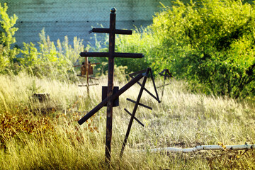 Grave crosses and tombstones stand in the old cemetery in Russia