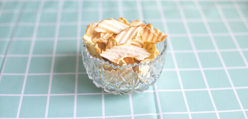 Dried apples, apple chips. Healthy snack, diet. Dried apples in a vintage plate on a turquoise background