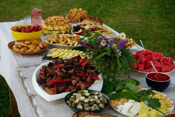 Traditional midsummer festive table with fried meat - shashlik, cheese, pies, fruit and other snacks, Latvia