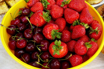 Yellow plastic plate with cherries and strawberries