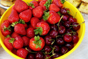 Yellow plastic plate with cherries and strawberries
