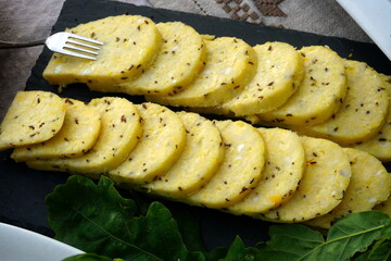 Homemade cheese with cumin cut and a plate. Traditional midsummer dish