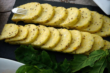 Homemade cheese with cumin cut and a plate. Traditional midsummer dish