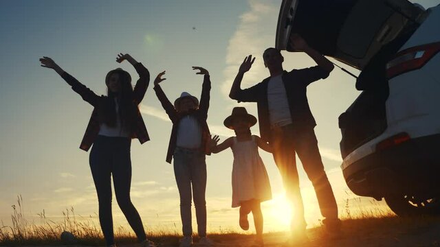 happy family wave goodbye campsite on a car outdoors silhouette at sunset. parents and kid children waving hands at the sunset nature. day off holiday friendly family dream teamwork concept. happy