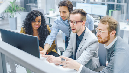 In Modern Office: Diverse Team of Businessmen and Businesswoman Work on Computer, Having Discussion, Successfully Finding Problem, Applaud and Cheerfully Celebrate. Happy and Motivated Businesspeople 