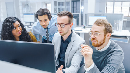 In Modern Office: Diverse Team of Young Motivated Businessmen and Businesswoman Work on Computer, Having Discussion, Finding Problem Solution Collectively. Ambitious Businesspeople Successful Teamwork