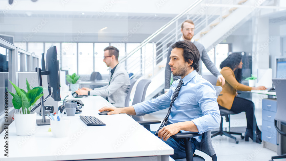 Wall mural young happy businessman returns to work after vacation into bright modern office, takes his working 