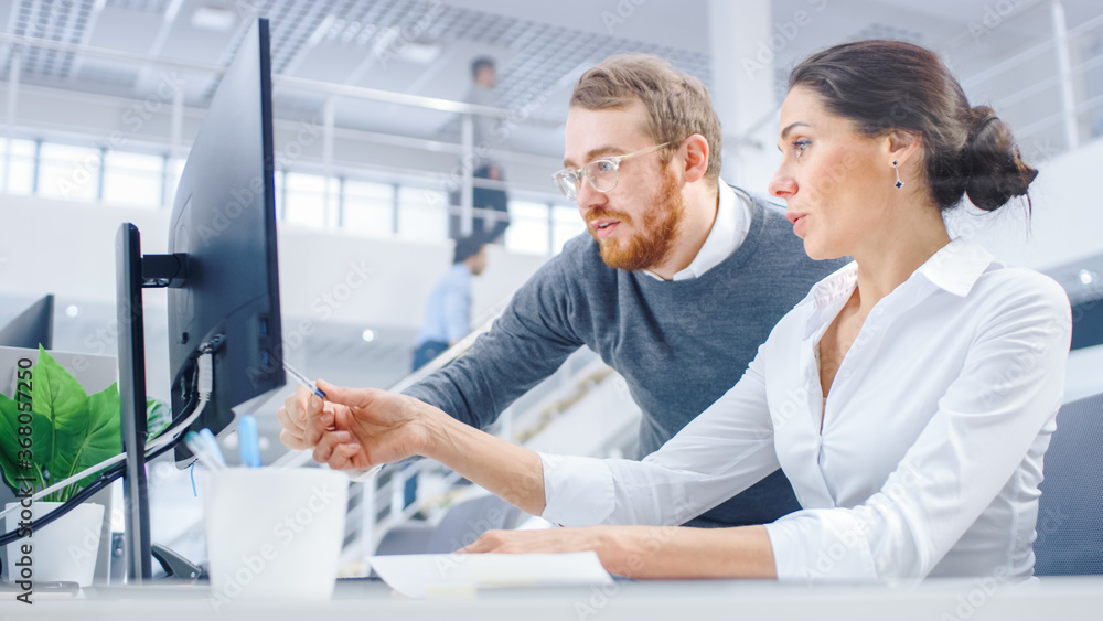 Poster beautiful businesswoman uses desktop computer, consults her project manager about documents with gra