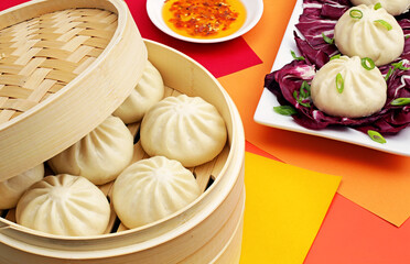Chinese steamed buns filled with pork and seasoning in traditional bamboo steamer