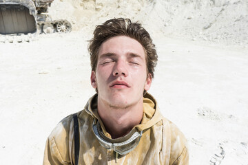 close-up of a man's face among the white sand. Sweat on the face. Stalker in the post-apocalyptic...
