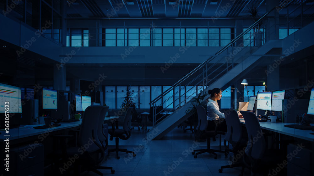 Aufkleber alone working late at night in the office: businesswoman using desktop computer, analyzing, using do