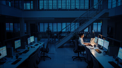 Alone Working Late at Night in the Office: Businesswoman Using Desktop Computer, Analyzing, Using Documents, Solving Problems, Finishing Project