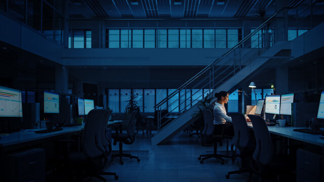Alone Working Late at Night in the Office: Businesswoman Using Desktop Computer, Analyzing, Using Documents, Solving Problems, Finishing Project