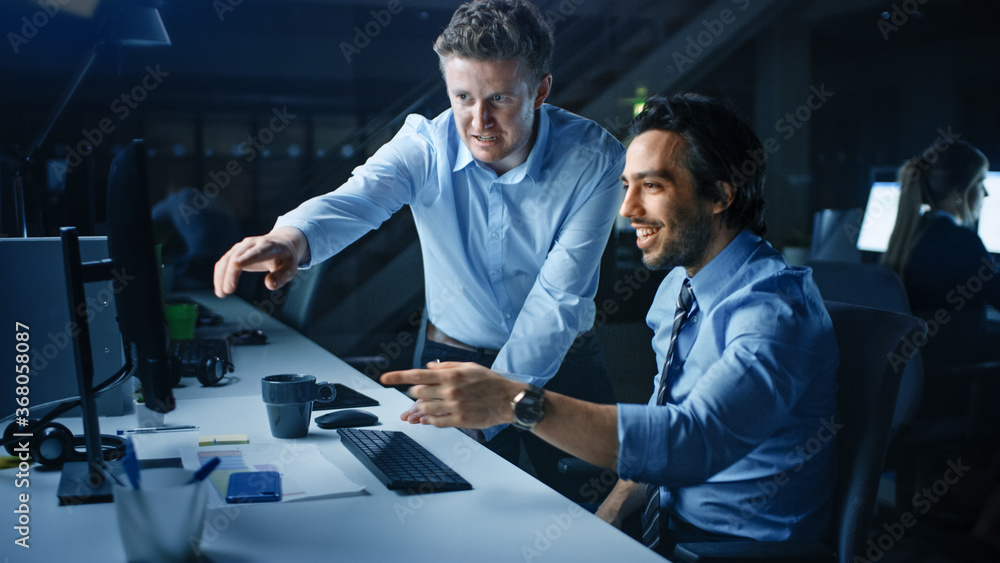 Poster ambitious and confident businessman uses desktop computer, his project manager explains specific tas
