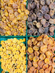 Dried apricots of four different types in a tray for sale on the market. Dried fruits and healthy food.