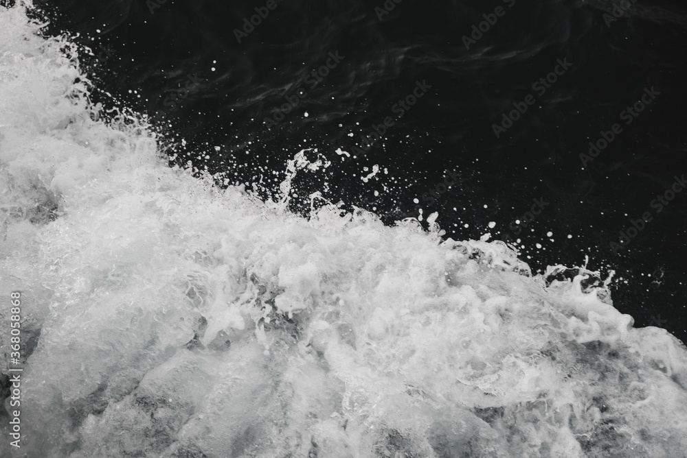 Poster closeup shot of splashing waves isolated on dark background