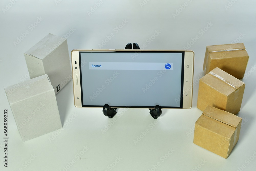 Aufkleber high angle shot of a mobile device with a search tab open next to carton boxes