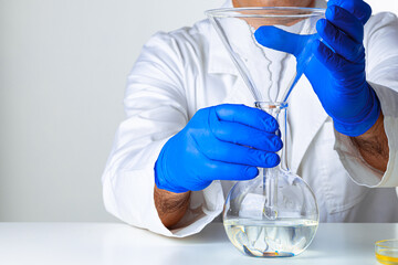 Scientist hands holding some liquid in a glassware in laboratory for analysis
